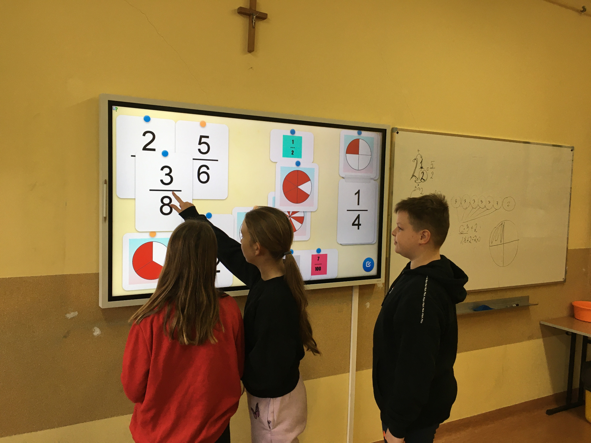 Troje uczniów rozwiązuje zadanie interaktywne z Learning Apps