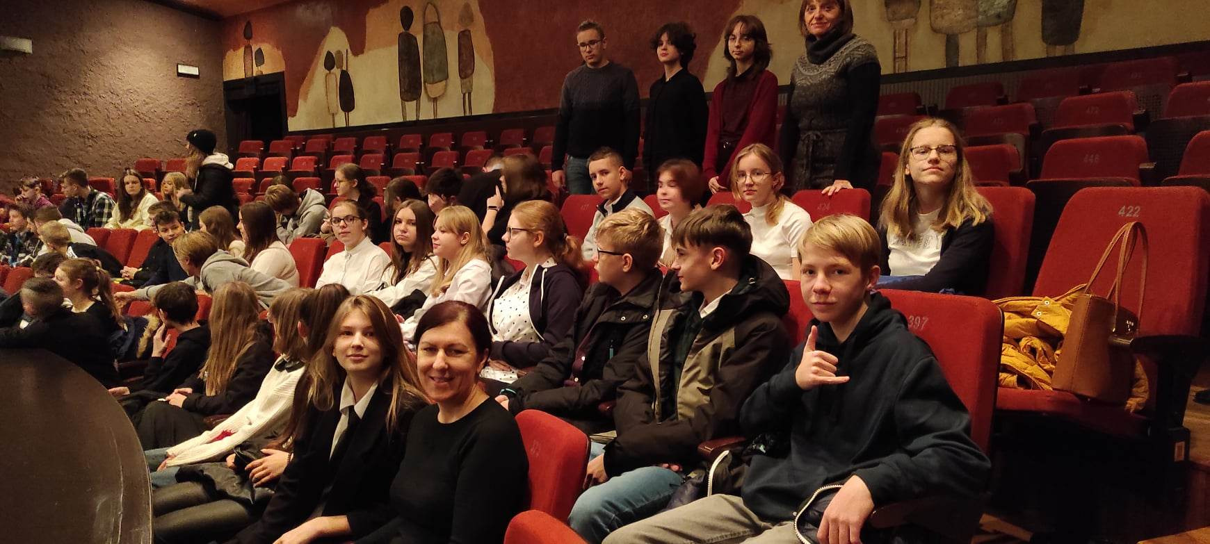 Uczniowie razem z nauczycielami siedzący i czekający na przedstawienie w Oświęcimskim Centrum Kultury