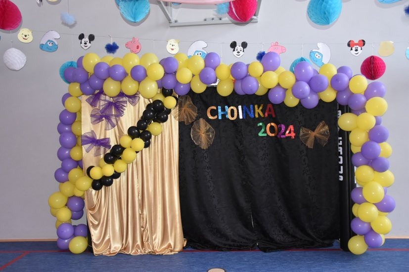 Ścianka fotograficzna ozdobiona balonami i napisem "Choinka 2024"