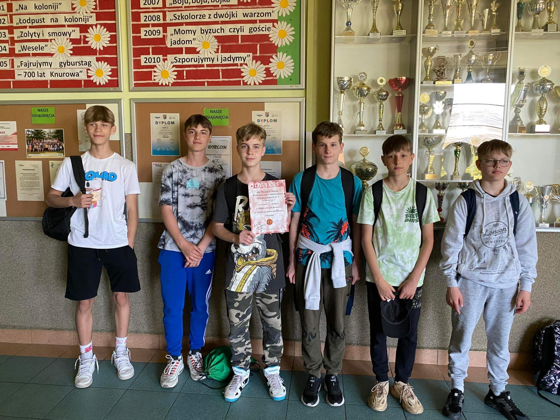 Grupa chłopców trzyma dyplom za zajęcie I miejsca w zawodach.