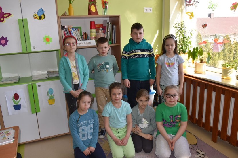 Grupa uczniów w strojach z elementami koloru zielonego