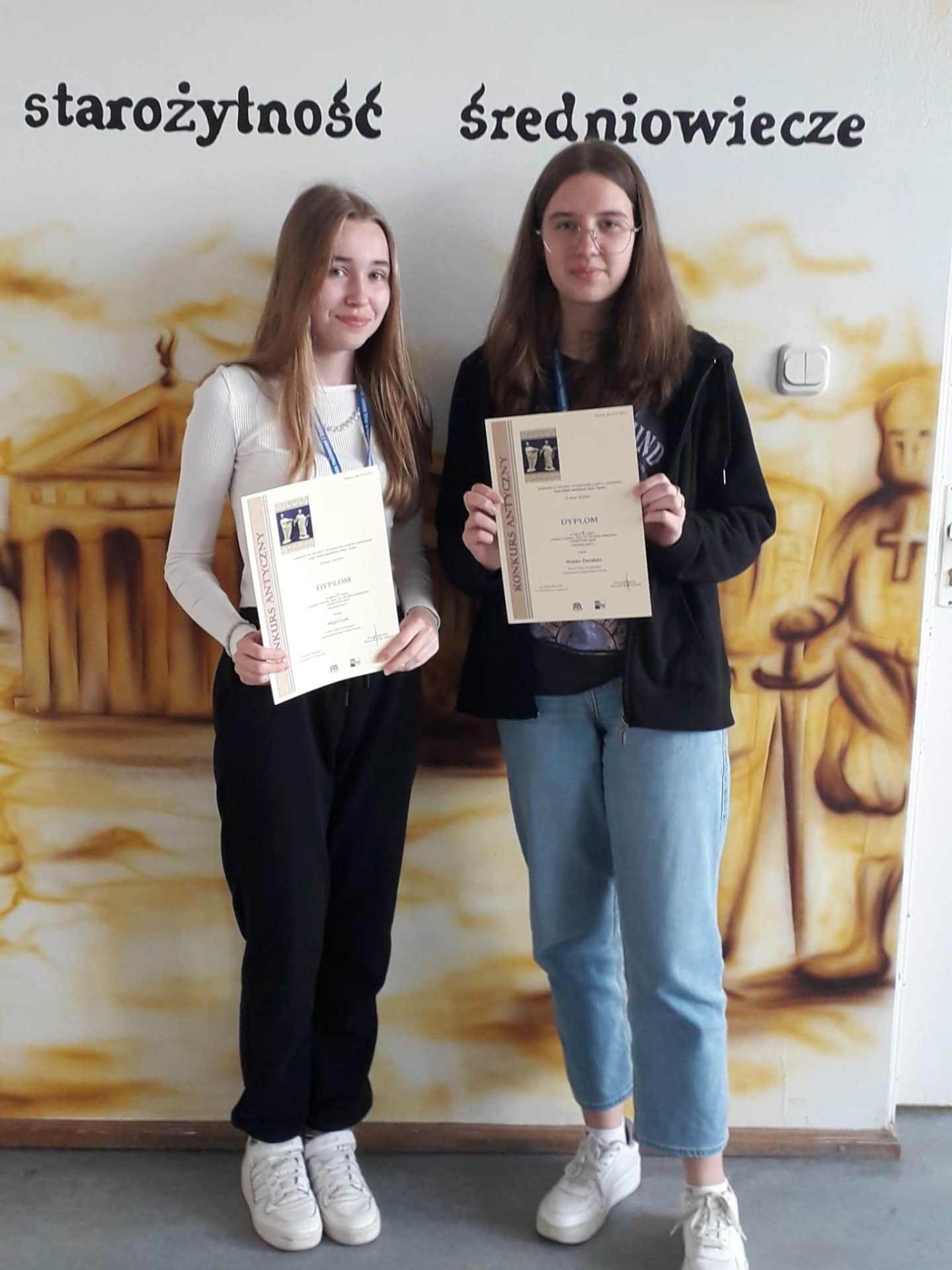 Maja Chyła i Monika Zawadzka z dyplomami za zajęcie II miejsca w konkursie na projekt gazety antycznej.