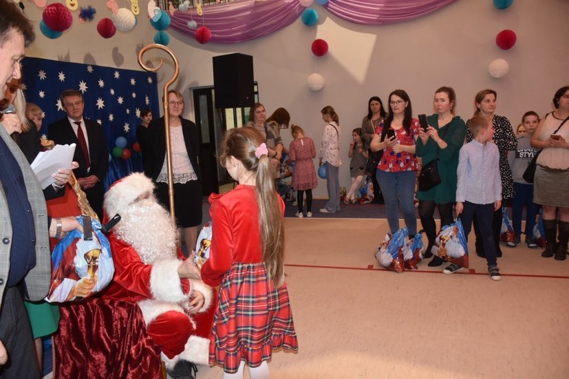 Mikołaj wręcza prezenty dzieciom w czasie Gminnej Choinki Noworocznej.