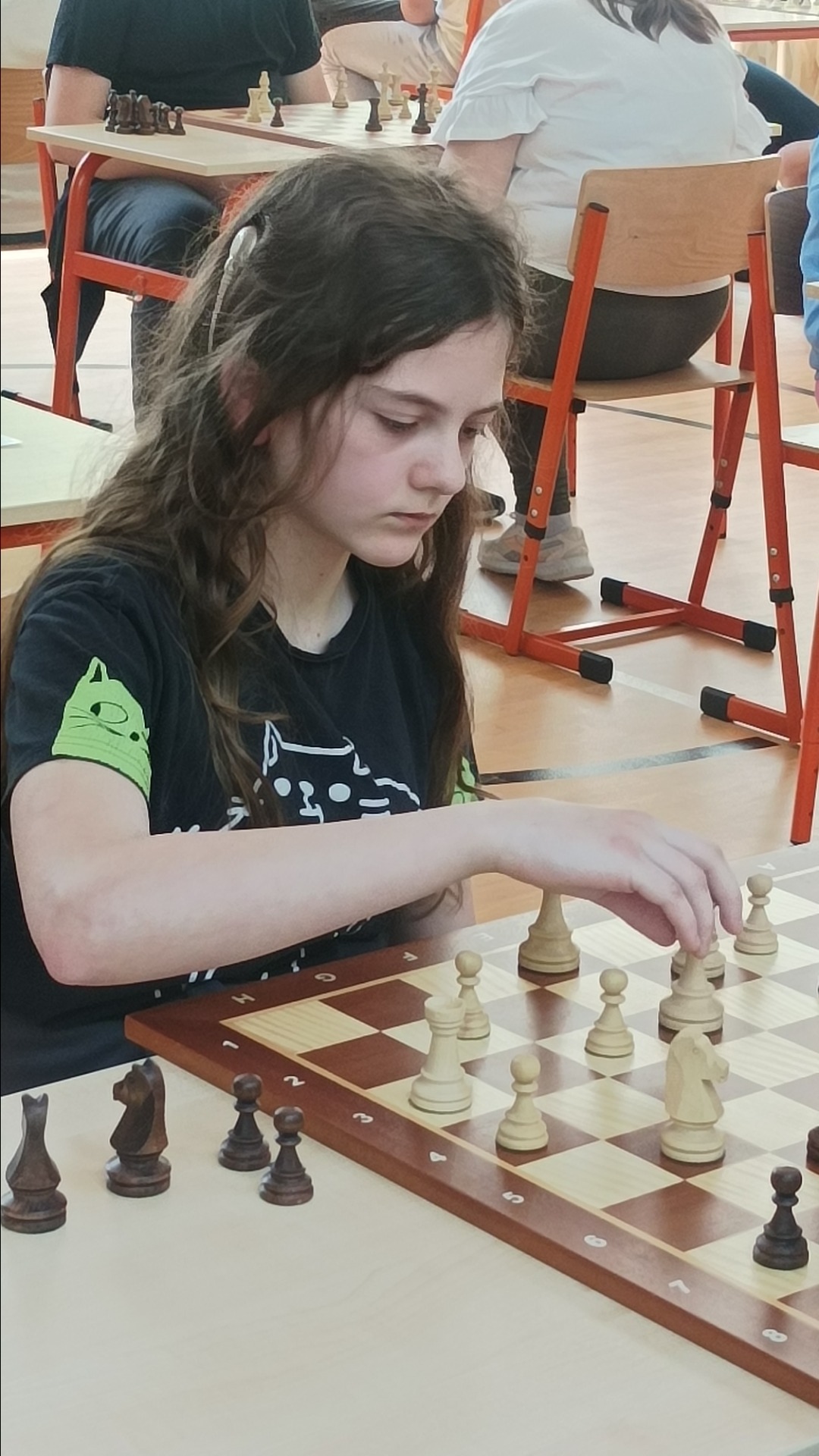 Uczennica rozgrywający partię w szachy.