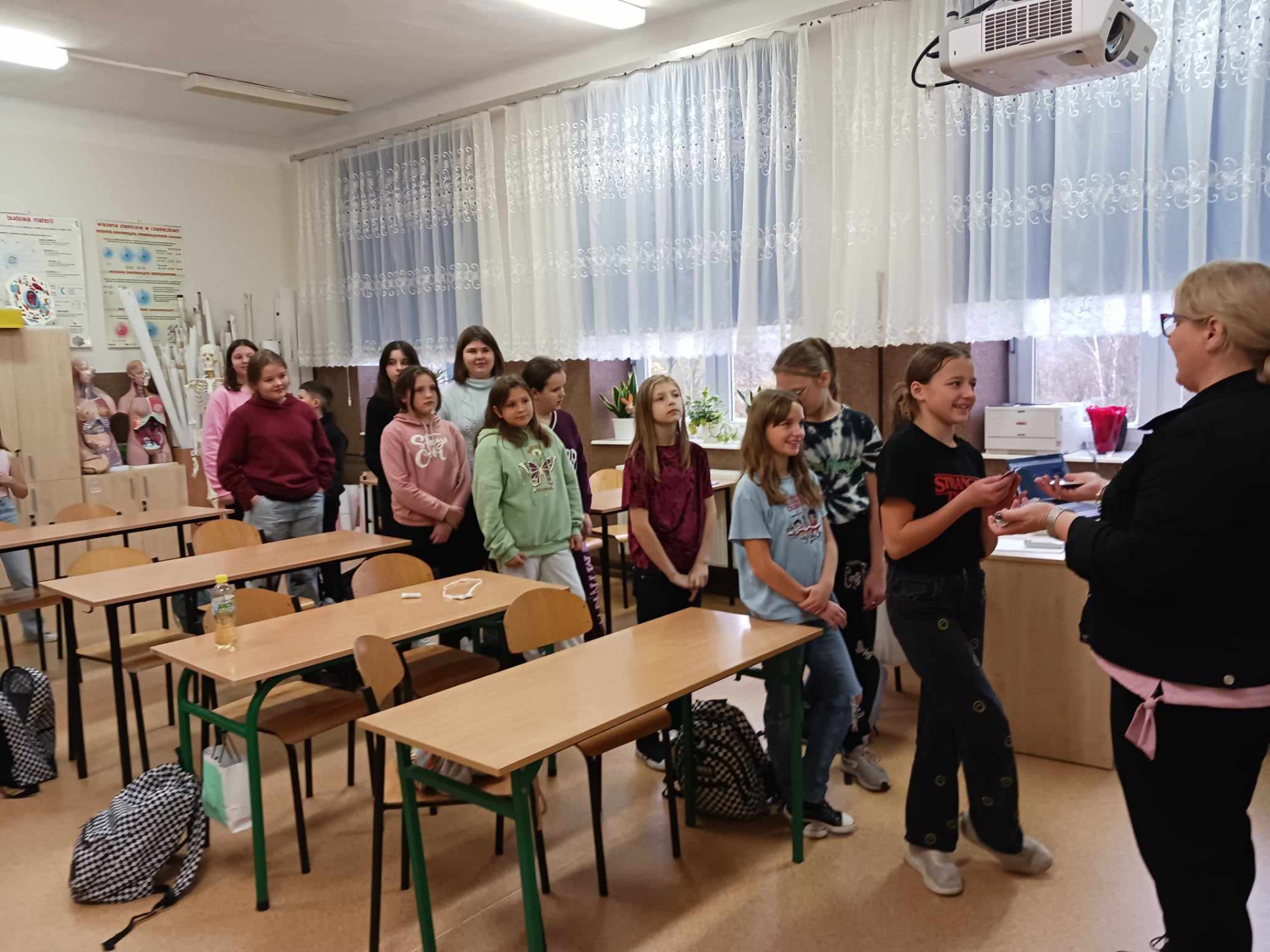 Zdjęcie przedstawia uczniów klasy piątej przygotowujących się do konkursu Światowego Dnia Tabliczki Mnożenia oraz panią Annę Jurgas.