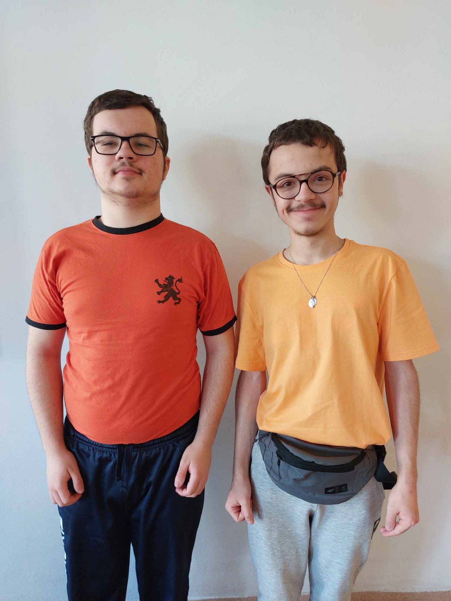2 chłopców  w pomarańczowych koszulkach