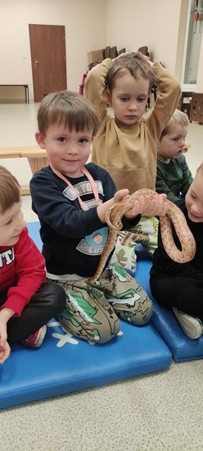 dziecko z wężem na rękach