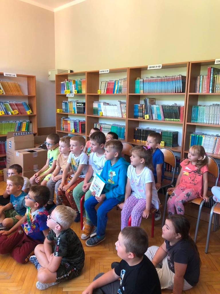 Grupa przedszkolna Skrzaty. W tle regały z książkami. 